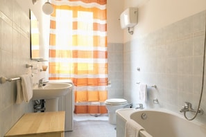 Un baño con lavamanos, inodoro, bañera y ducha.