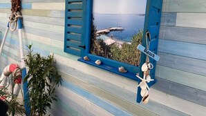 A room with a view of a dock and water, decorated with seashells and a starfish. - Hotel Lilia 2 (Primorsko)
