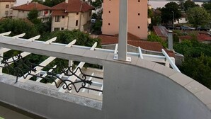 A balcony with a view of a coastal town, including buildings and a body of water. - Hotel Lilia 2 (Primorsko)