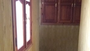 A hallway with wooden walls, a tiled floor with geometric patterns, and wooden cabinets in the background. - Sweet Azrou Holiday (Azrou)