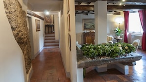 A stone bench with plants, a staircase, and a dining area with chairs and a table. - B&B Arena di Lucca (Lucca)