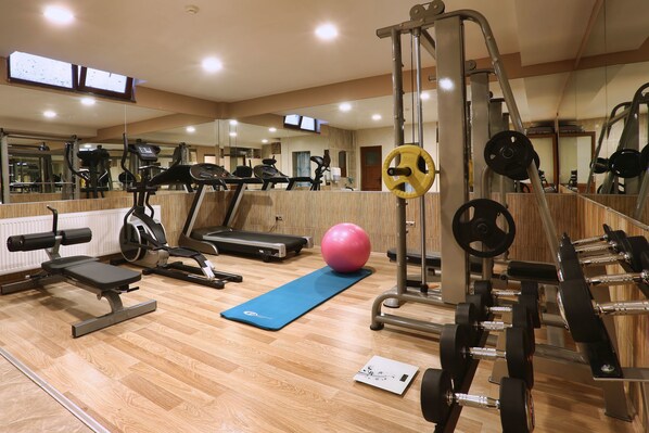 A gym with exercise equipment, a blue mat, and a pink exercise ball. - Balturk House Hotel (Izmit)