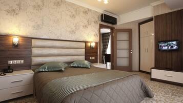 A bedroom with a large bed, bedside tables, a TV, and a wardrobe.