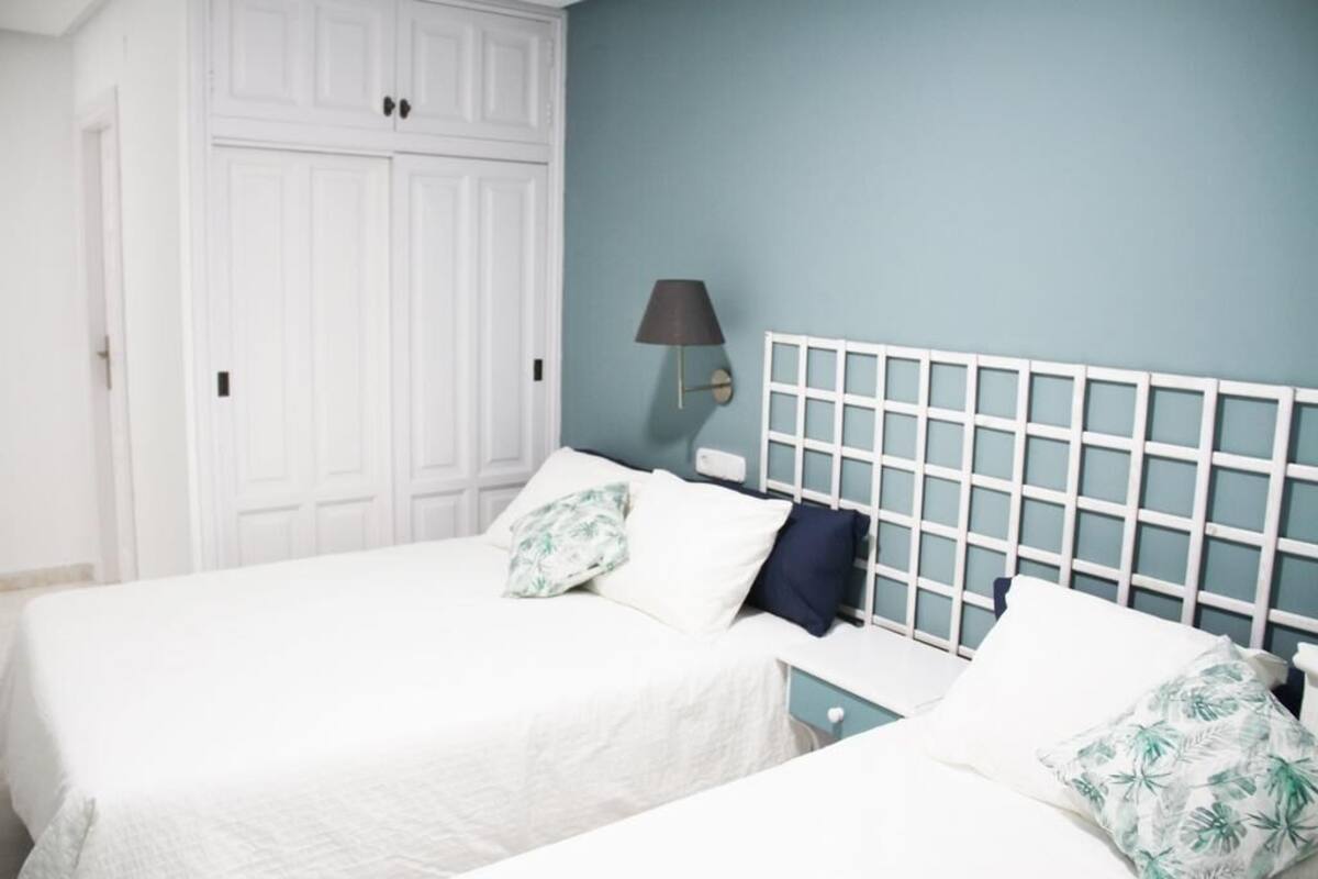 Une chambre à coucher avec un lit, une armoire et une table de chevet.