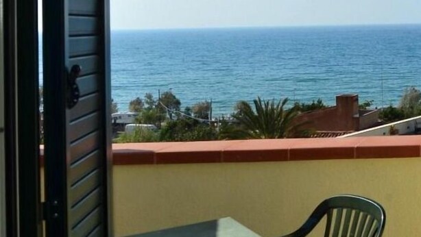 A balcony with a view of the sea, a table, and a chair. - Holidays Cefalù (Cefalù)