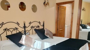 A bed with a black metal frame, white bedding, and a dark blue throw blanket. - Antiguo Casino de los Arribes (Fermoselle)