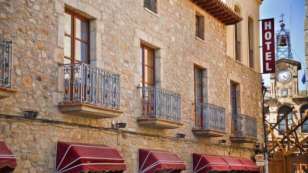 A stone building with a balcony, awnings, and a clock tower. - Antiguo Casino de los Arribes (Fermoselle)