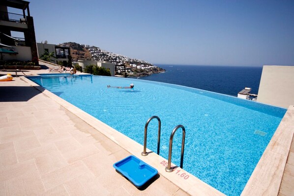 Utomhuspool, parasoller och solstolar