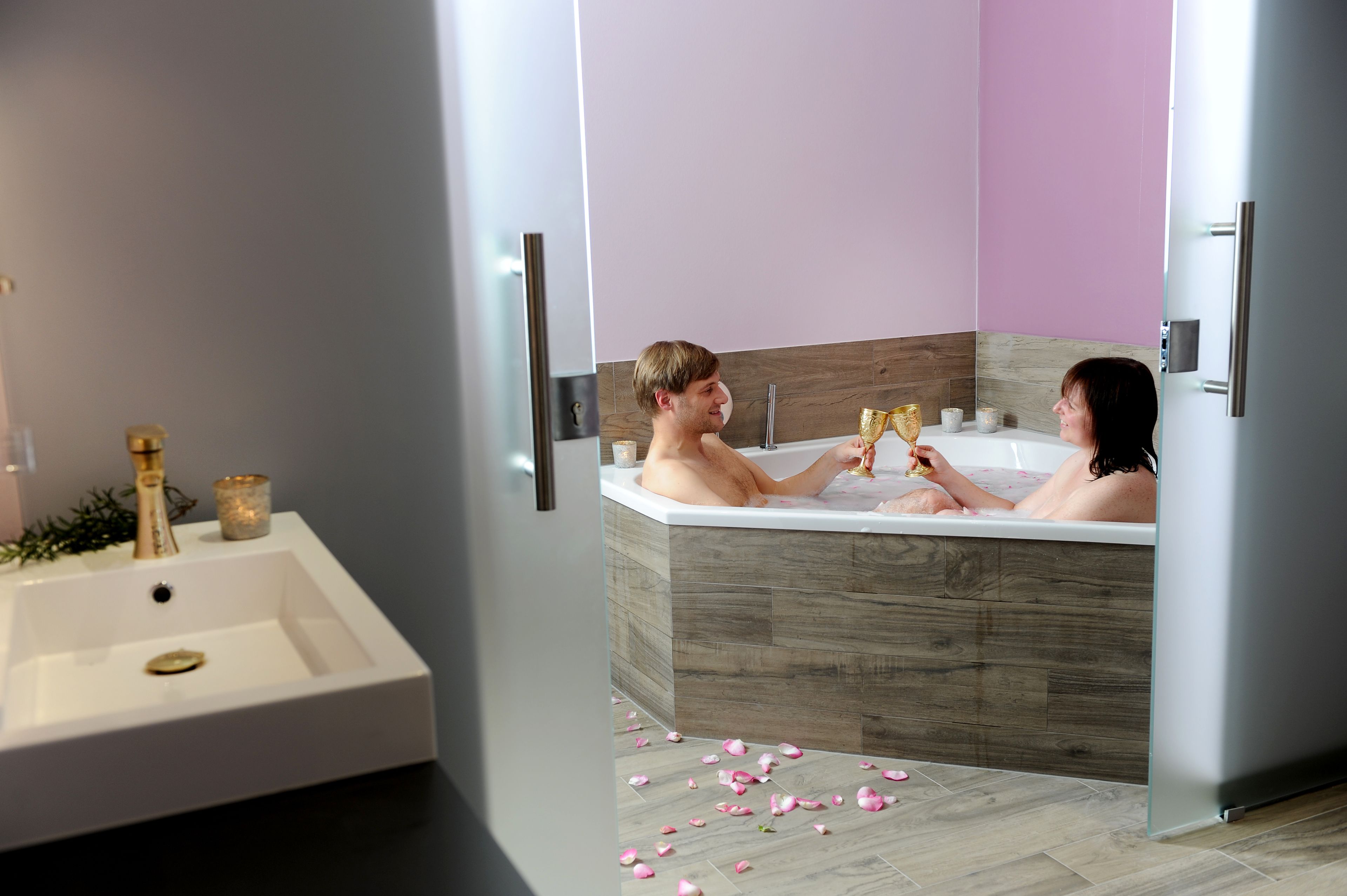 Ein modernes Badezimmer mit einer Badewanne, einem Waschbecken und einem Spiegel.