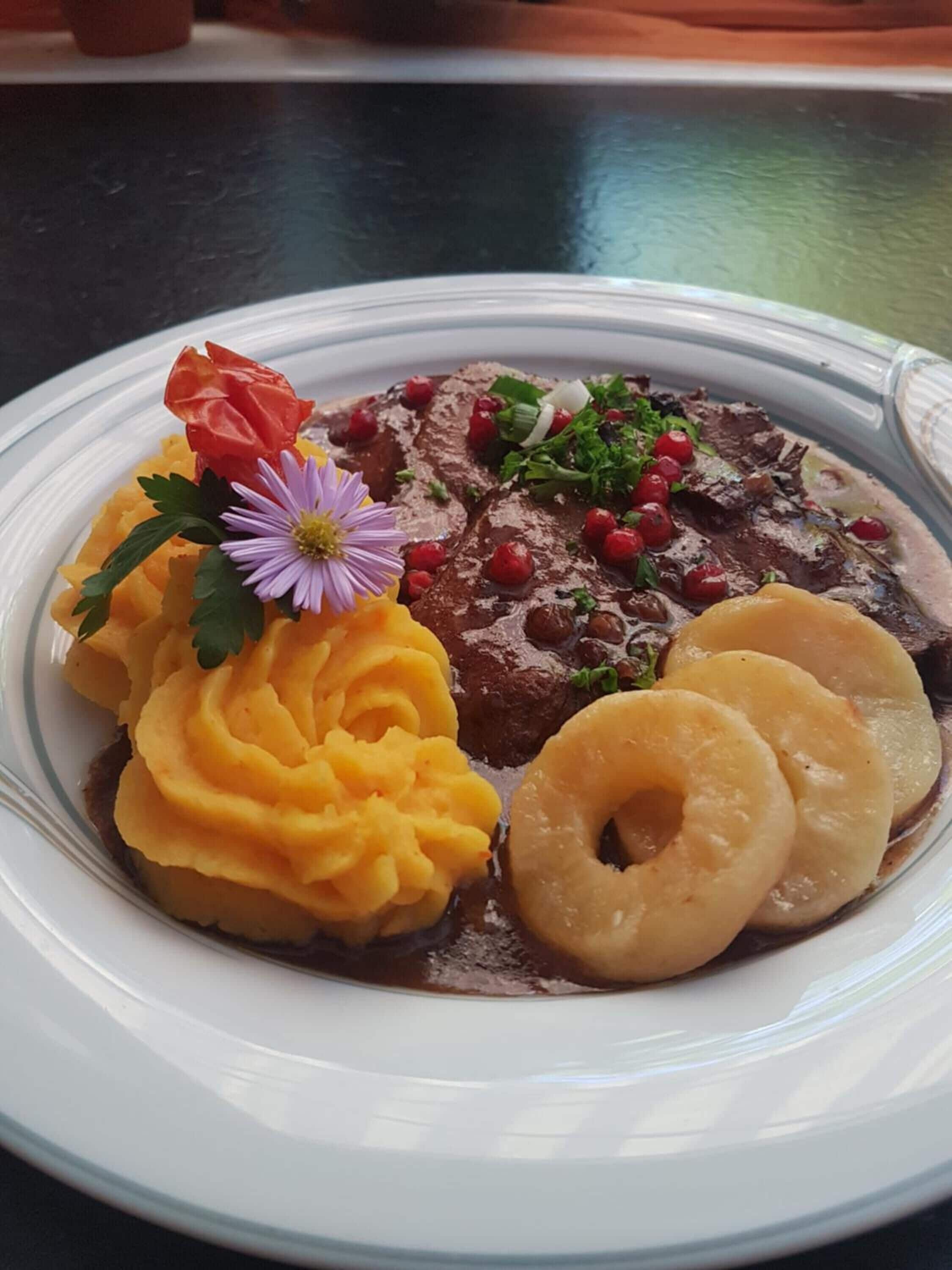 A plate with mashed potatoes, sliced meat, and boiled potatoes.