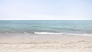 Ein Strand mit blauem Himmel und ruhiger See.