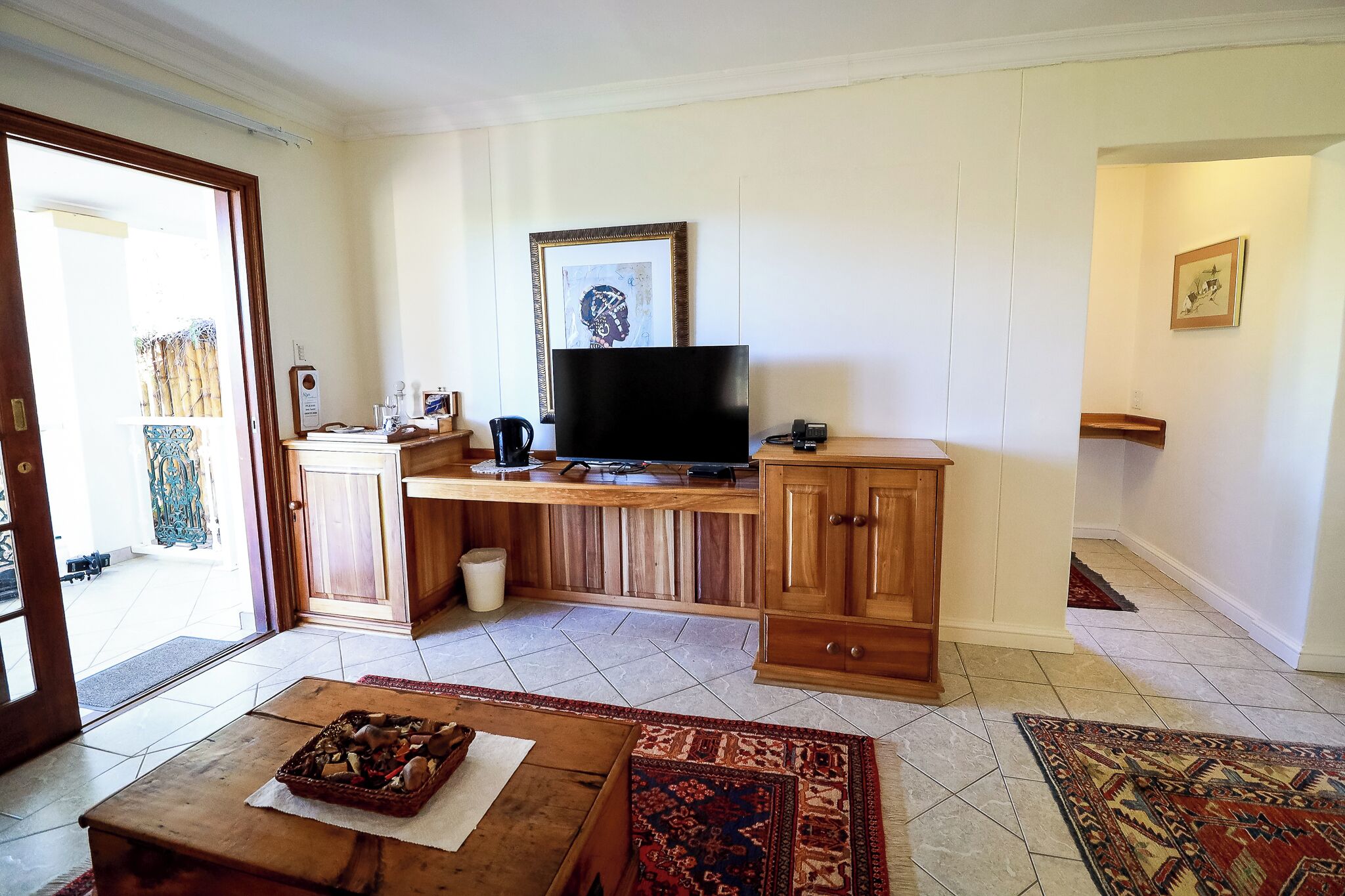 A living room with a wooden TV stand, a television, a cabinet, and a coffee table.