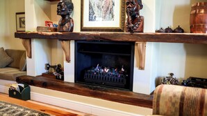 Ein gemütliches Wohnzimmer mit Kamin, Holzregalen und Dekoration.