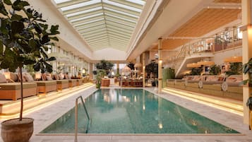 Alberca techada, alberca al aire libre y camastros