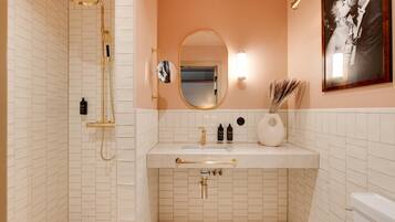 Un baño con ducha, lavabo e inodoro.