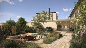 A courtyard with a fire pit, outdoor seating, and a variety of plants and flowers. - Hjortviken Country Club (Hindas)