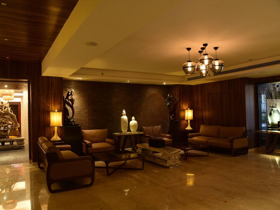 A modern lobby with leather sofas, a coffee table, and decorative lamps.