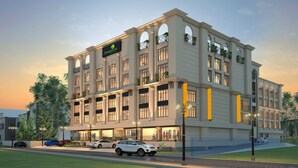 A multi-story hotel with a classic architectural style, featuring large windows and balconies with plants. - Lemon Tree Hotel Siliguri (Jalpaiguri)