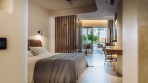 A modern hotel room with a large bed, a dining area, and a view of the outdoors.