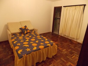 Escritorio, cortinas blackout y tabla de planchar con plancha