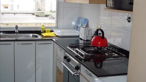 A modern kitchen with a gas stove, a microwave, and a sink. - Palermo Open View (Buenos Aires)