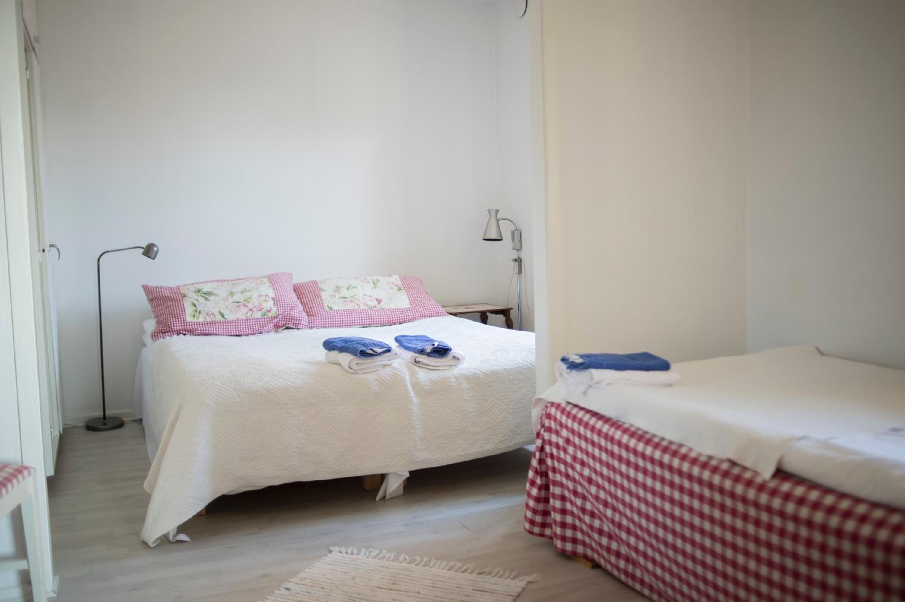 A bedroom with a bed, a bedside table, a lamp, and a chair.