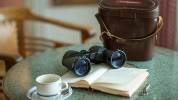 Une table avec des jumelles, un livre, une tasse et une clé.