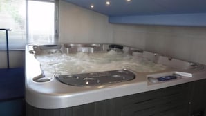 A hot tub with multiple jets, a built-in seat, and a control panel.