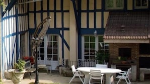 A traditional half-timbered building with a round table and chairs in the courtyard.
