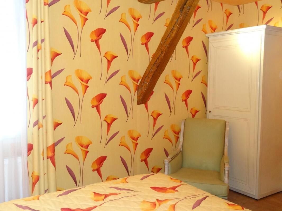 A room with a bed, a chair, and a wardrobe.