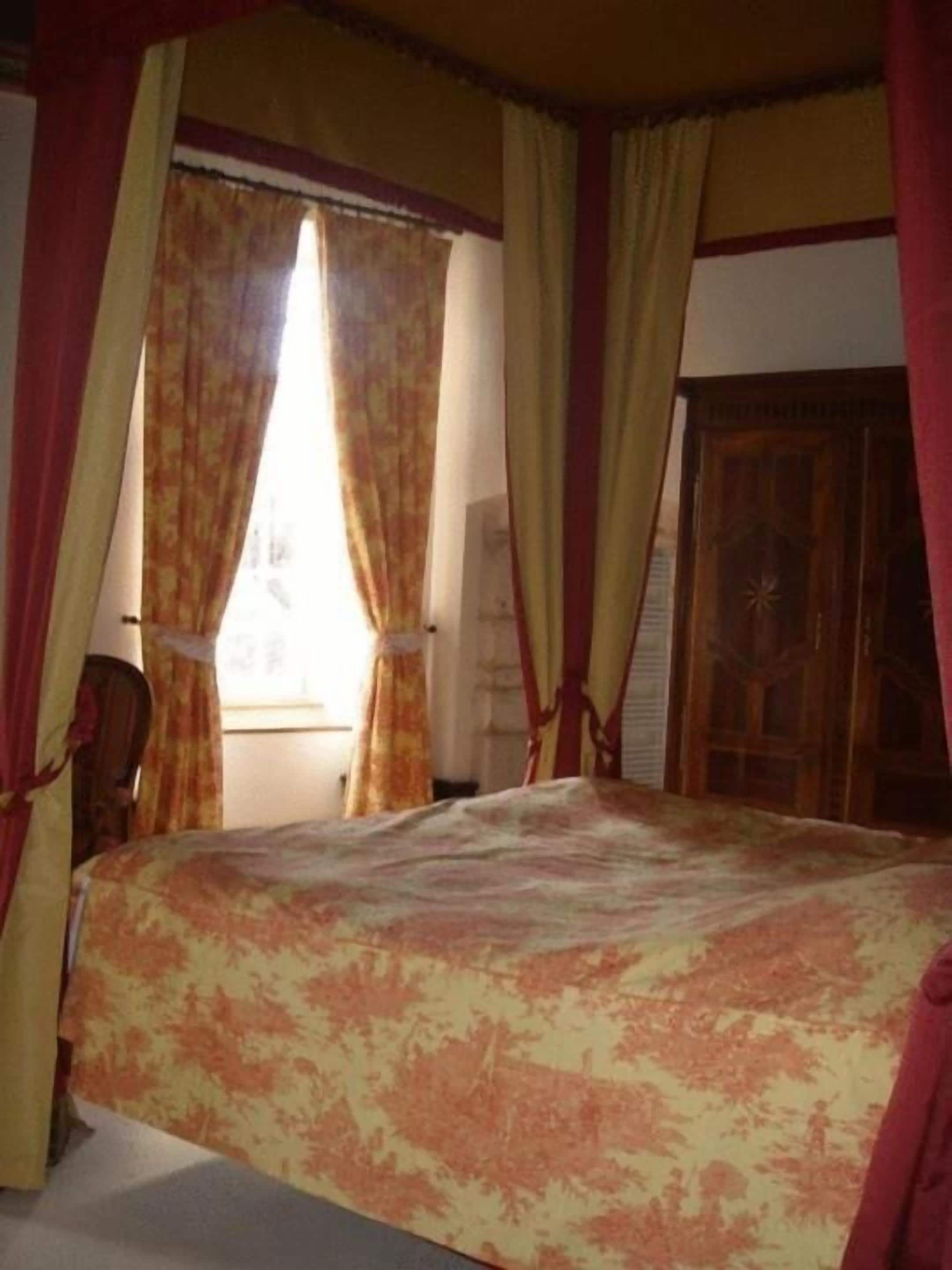 Un dormitorio con cama, cortinas y una puerta de madera.