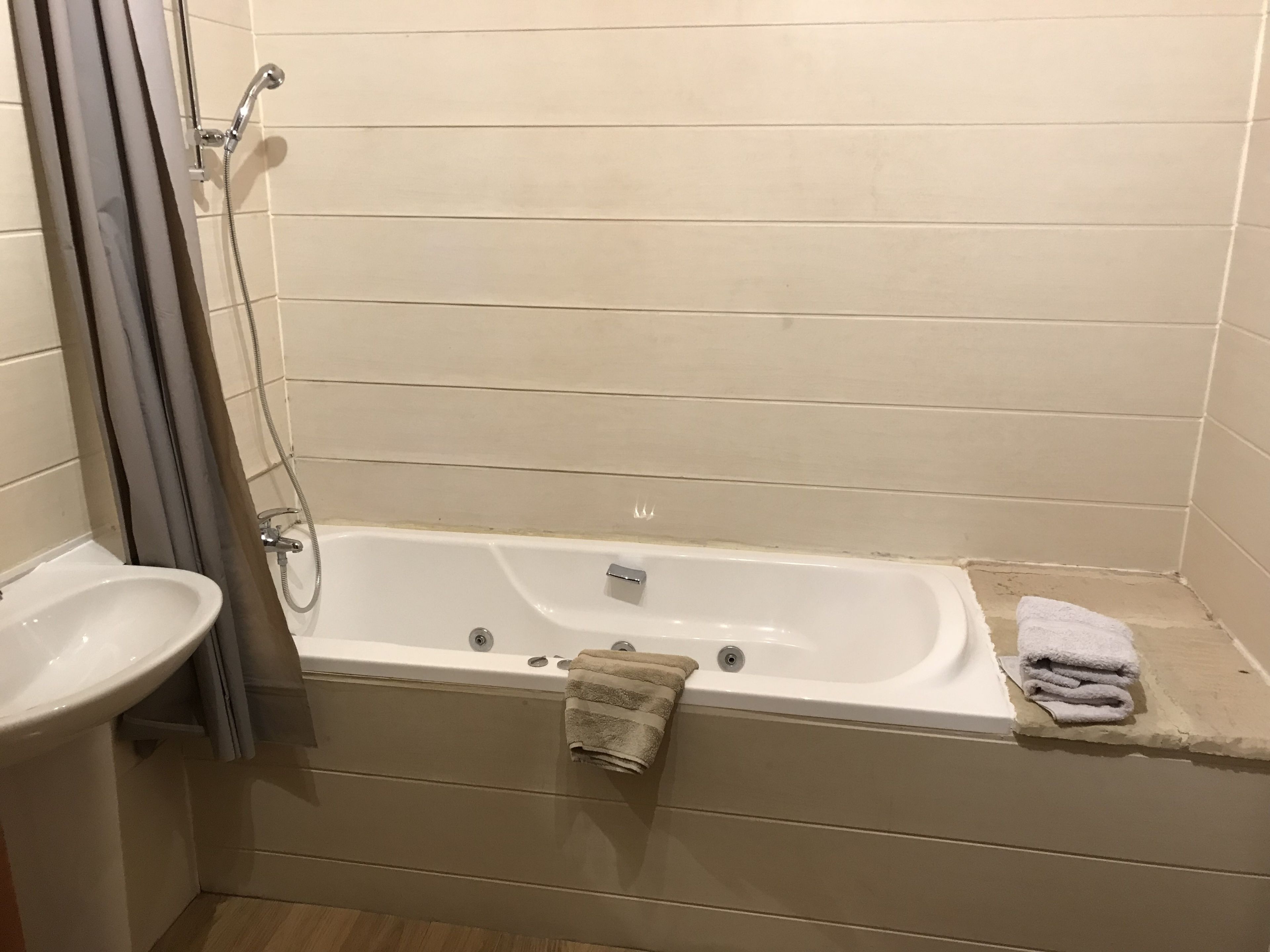 A bathroom with a bathtub, a sink, and a shower.