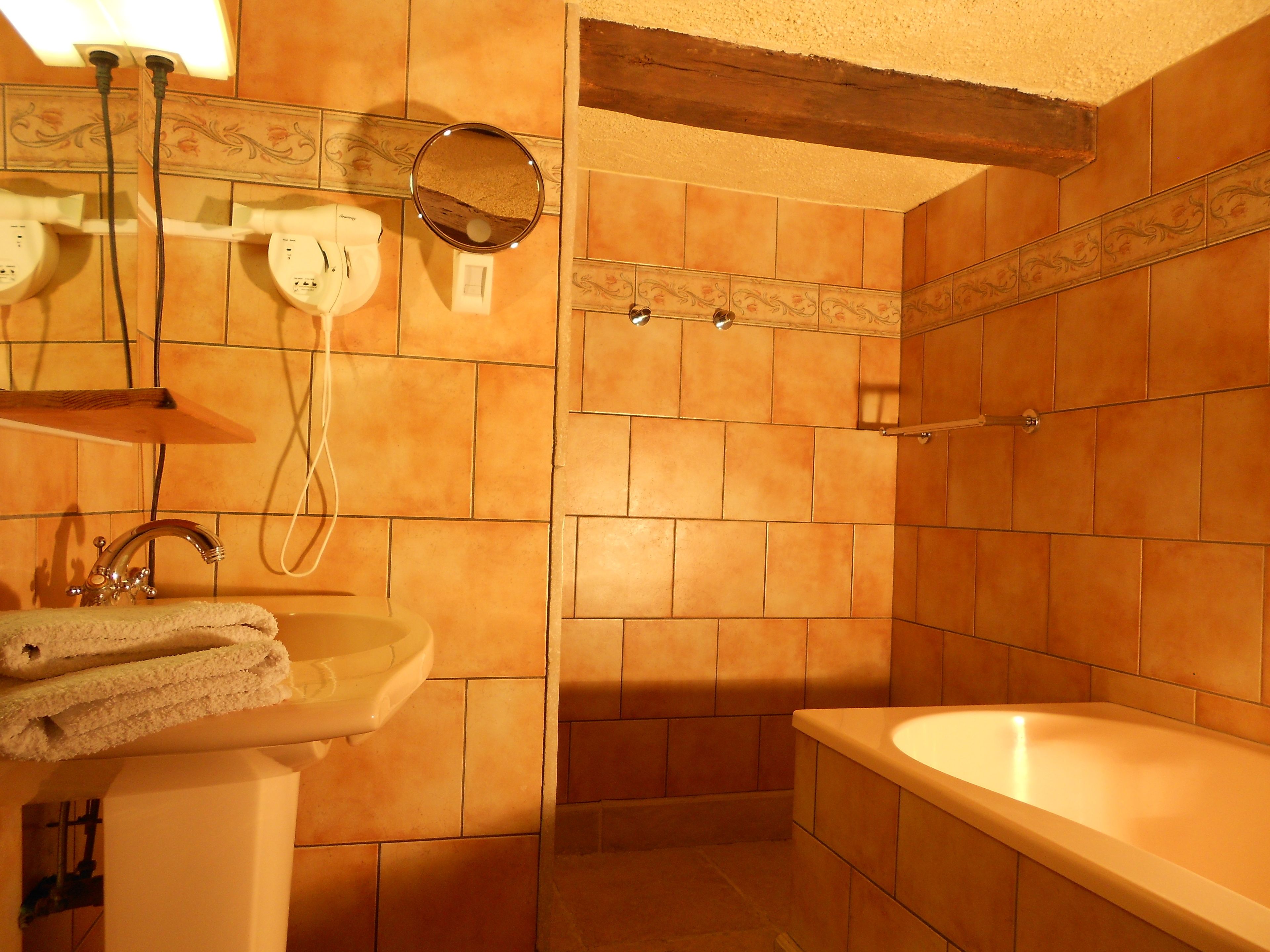 Un baño con lavamanos, espejo y bañera.