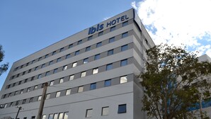 A modern hotel building with a sign reading "ibis HOTEL" on the top. - ibis budget Divinopolis (Divinopolis)
