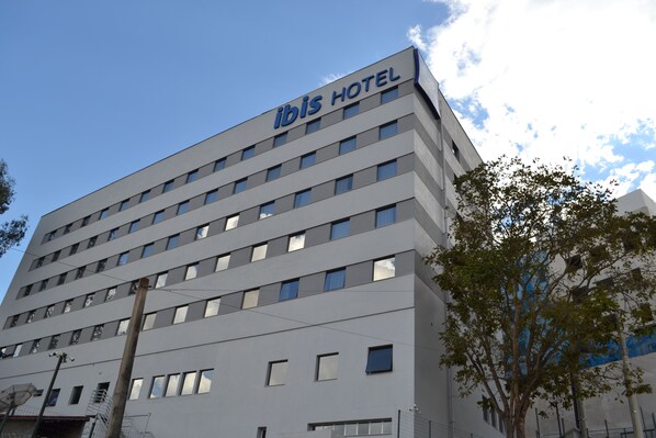 A modern hotel building with a sign reading "ibis HOTEL" on the top. - ibis budget Divinopolis (Divinopolis)