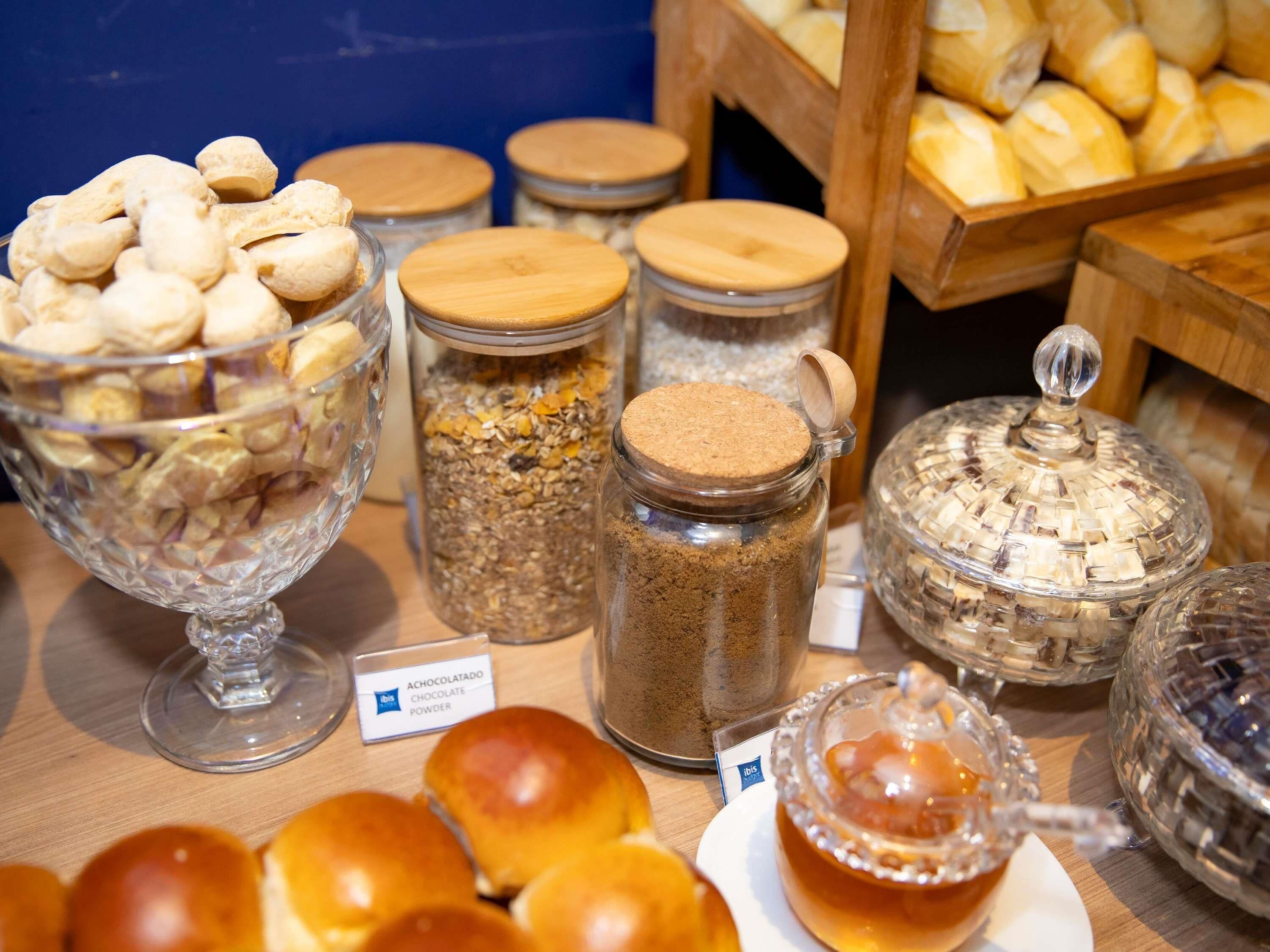 A buffet with various food items including cookies, granola, and bread.