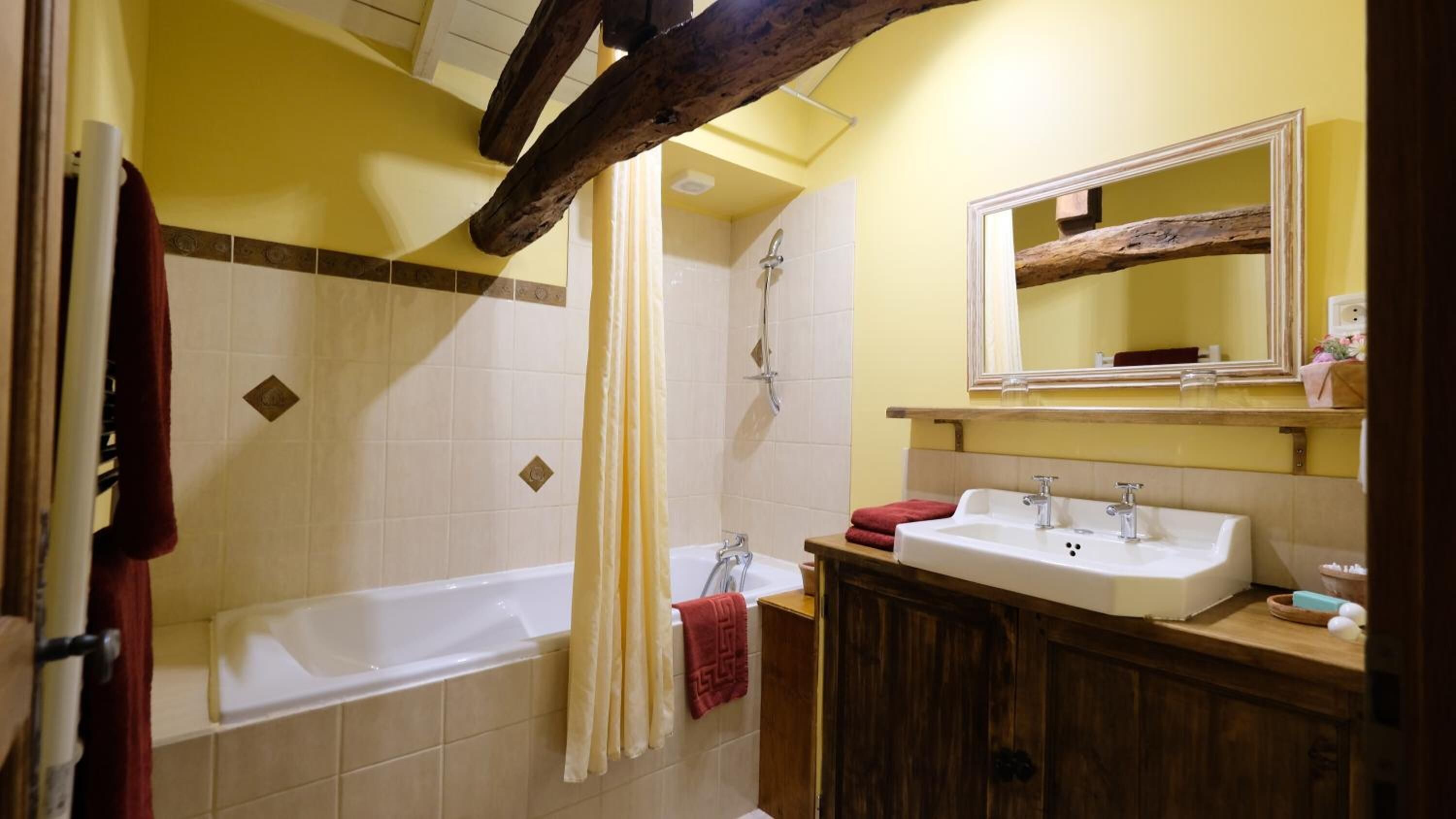 A bathroom with a bathtub, a shower, and a vanity with a sink.
