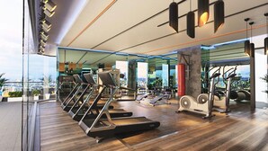Ein modernes Fitnessstudio mit Laufbändern, Crosstrainern und Kraftgeräten.