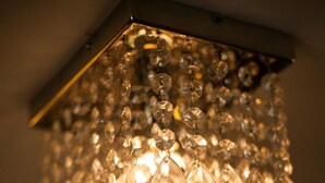 A chandelier with multiple crystal elements hanging from a metal fixture. - Holly Bush Inn (Hexham)