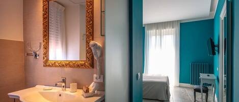 A bathroom with a large mirror, sink, and towel rack.