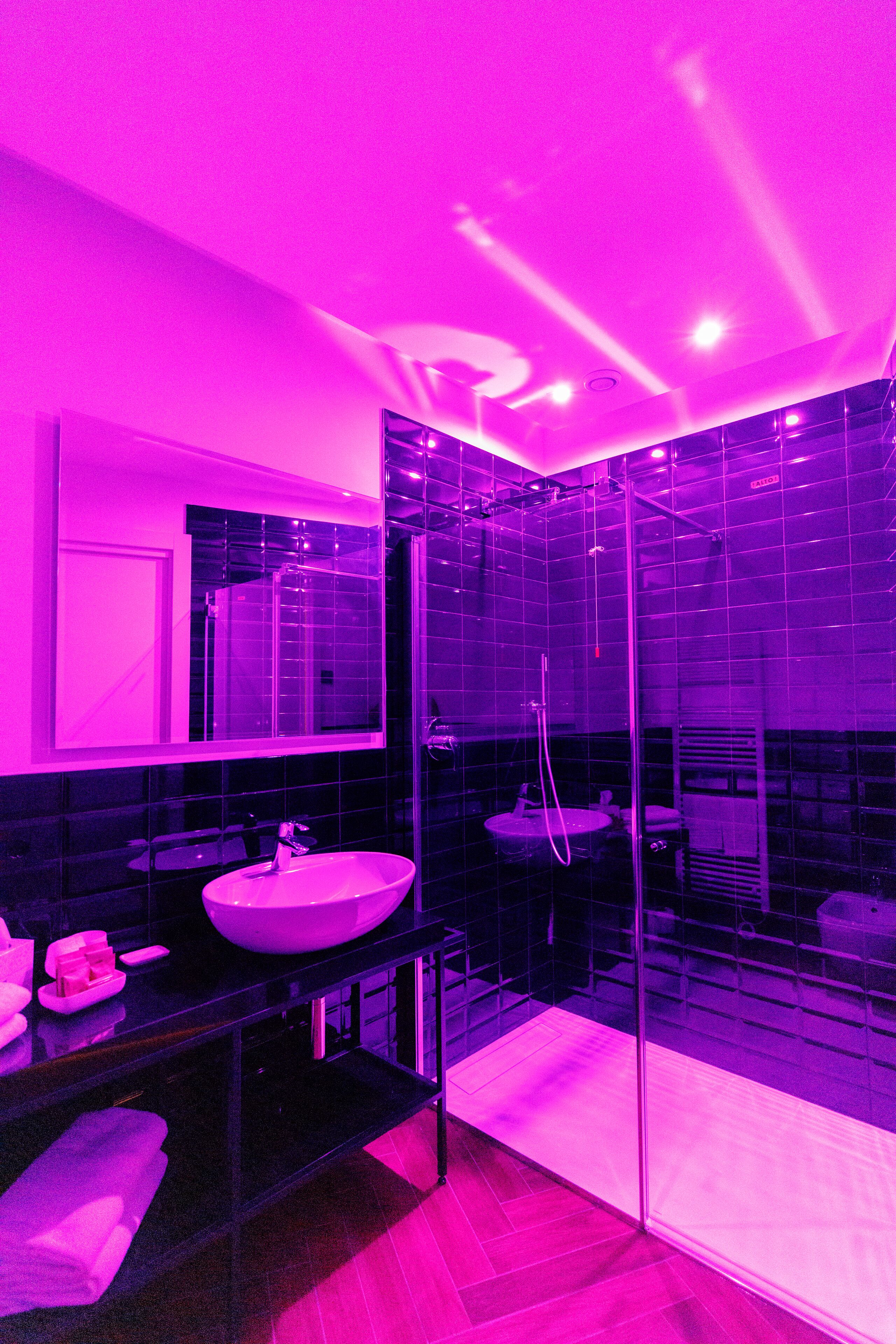 A modern bathroom with a glass shower enclosure, a large mirror, and two sinks.