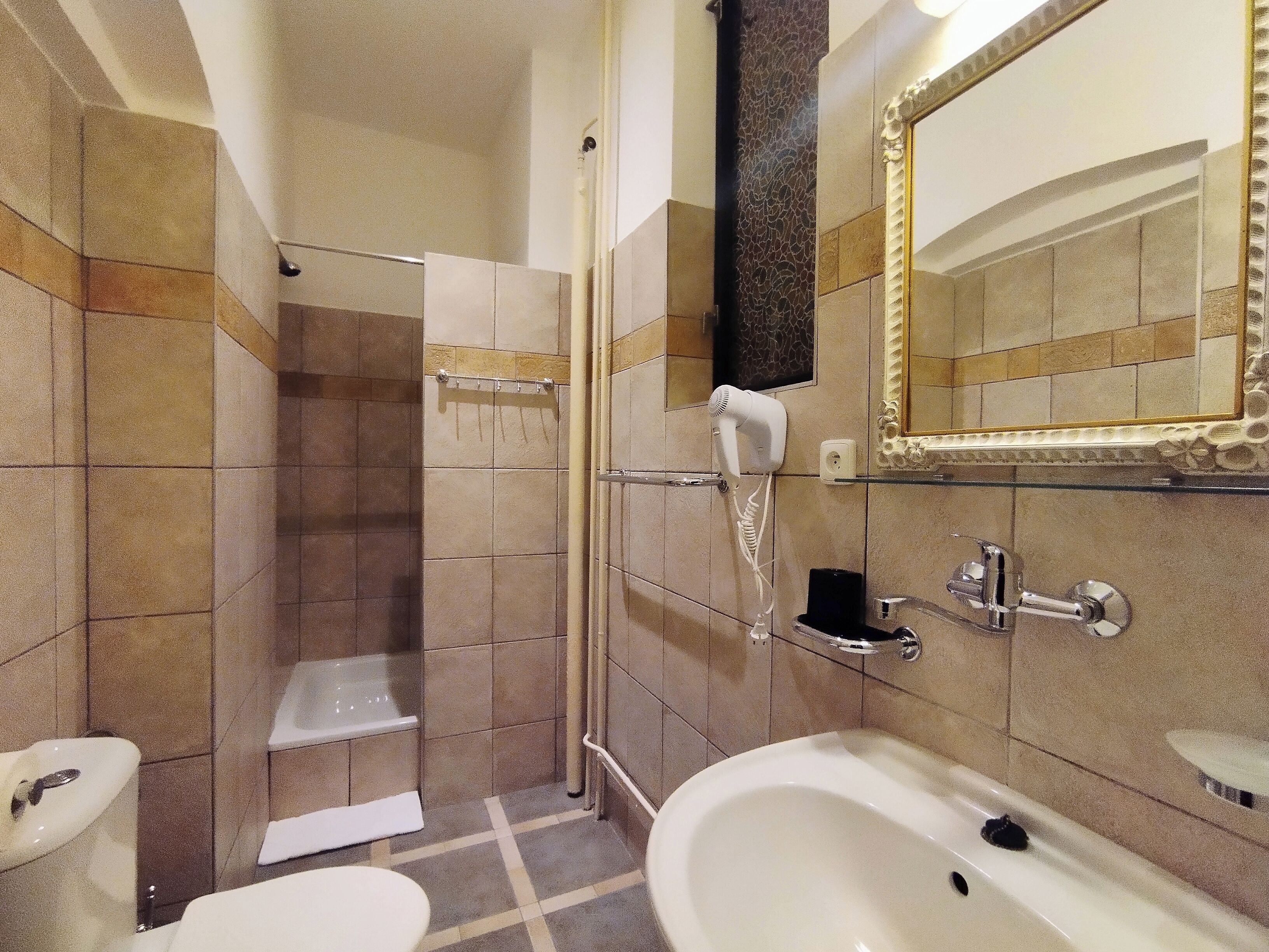 Un baño con ducha, inodoro, bidé y lavamanos.