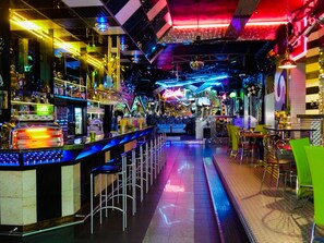 A bar area with a long counter, stools, and a variety of bottles and glasses. - Hotel Cade (Pisek)