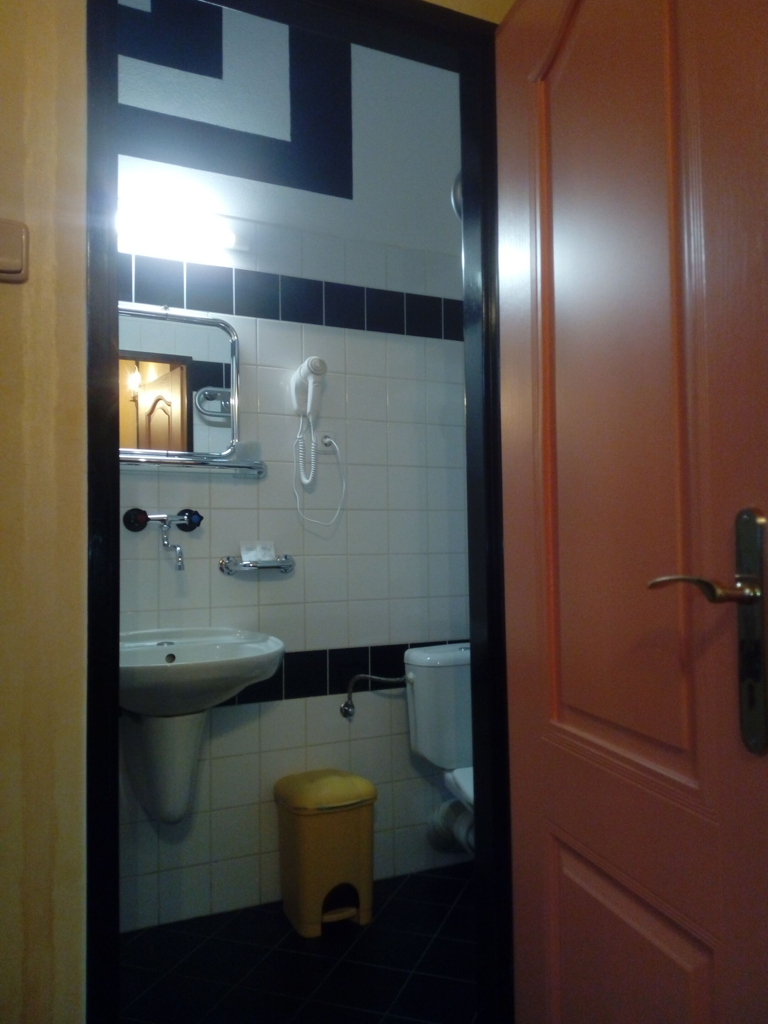 A bathroom with a sink, toilet, and a telephone.