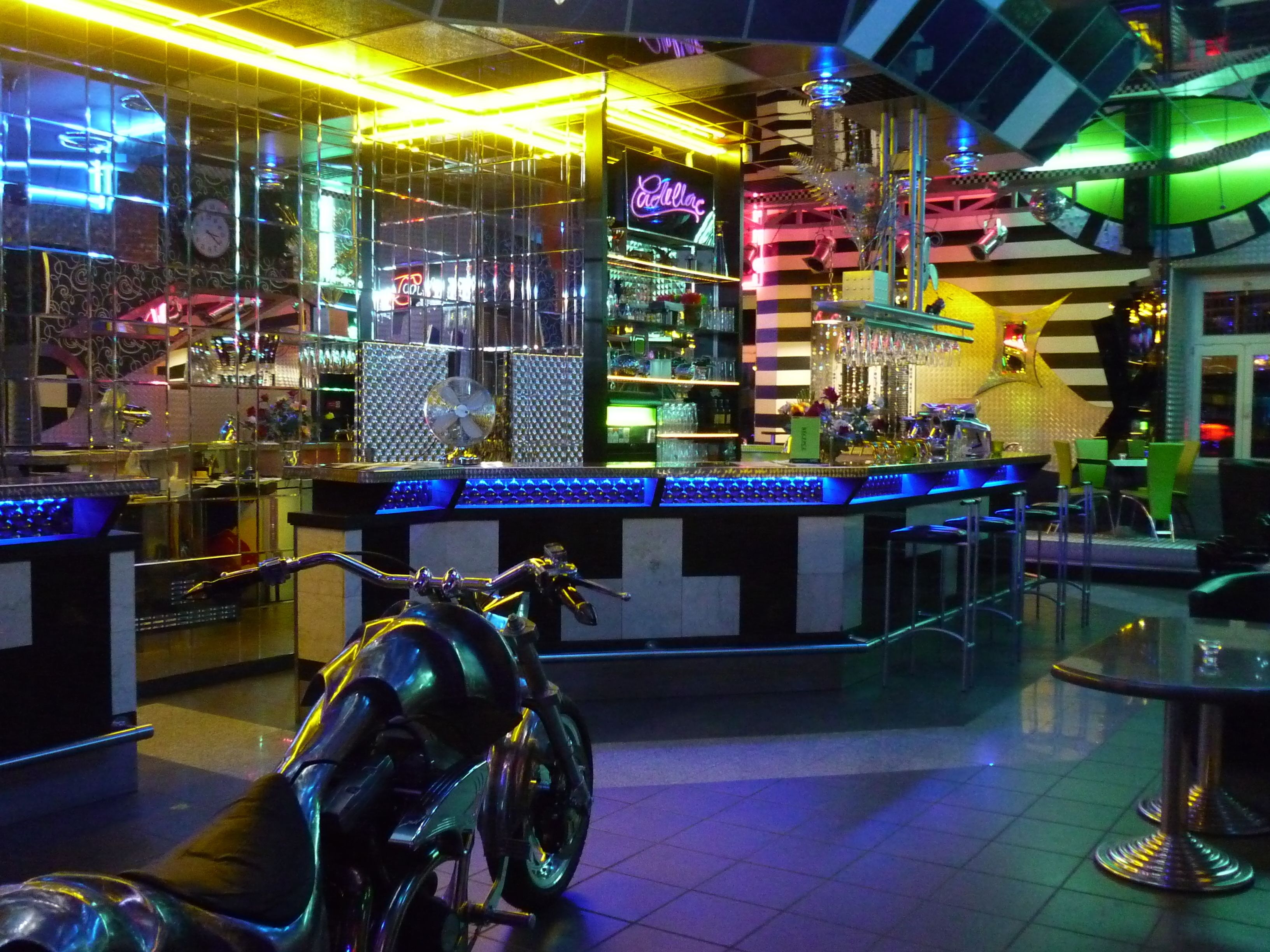 Zona de bar con una motocicleta, barra y asientos.
