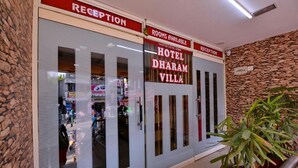 A hotel reception with a stone wall and a sign indicating rooms available. - Hotel Dharam Villa (Kalka)