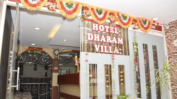 The exterior of Hotel Dharam Villa, featuring a traditional architectural style with a prominent entrance and decorative floral arrangements. - Hotel Dharam Villa (Kalka)