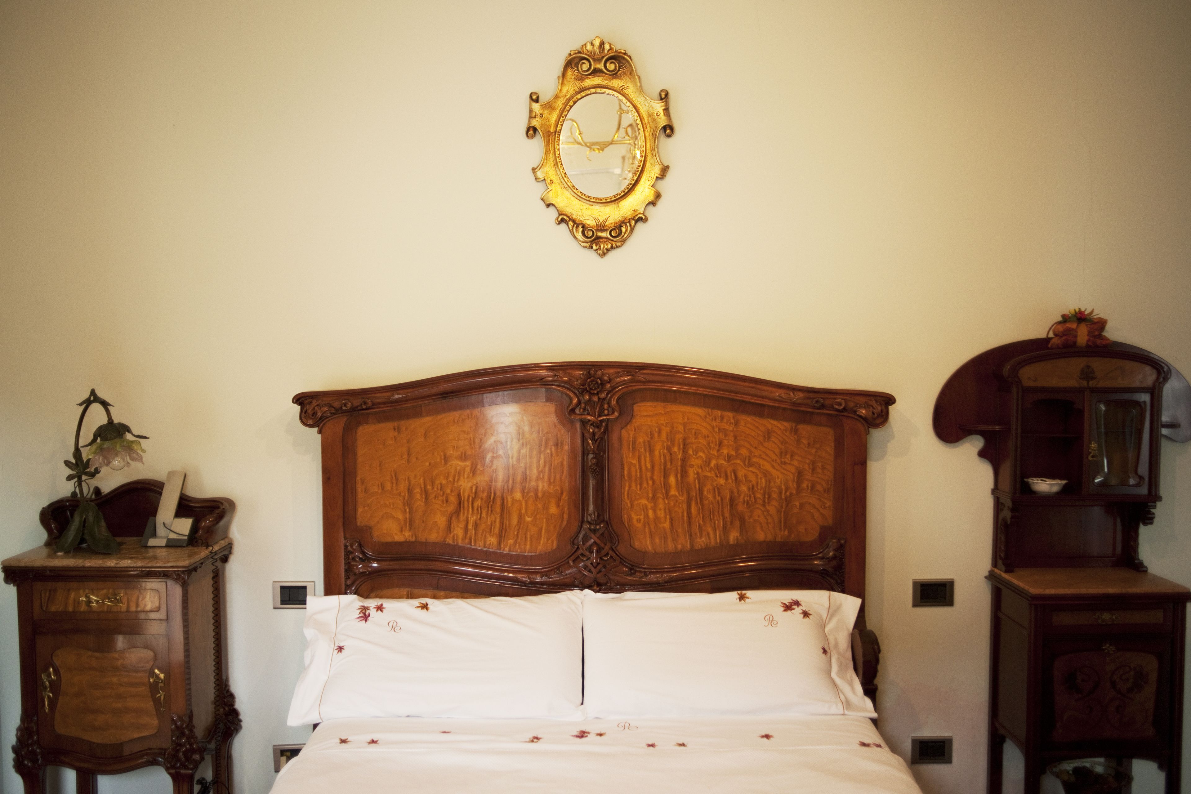 Un dormitorio con una cama de madera, un espejo y dos mesitas de noche.