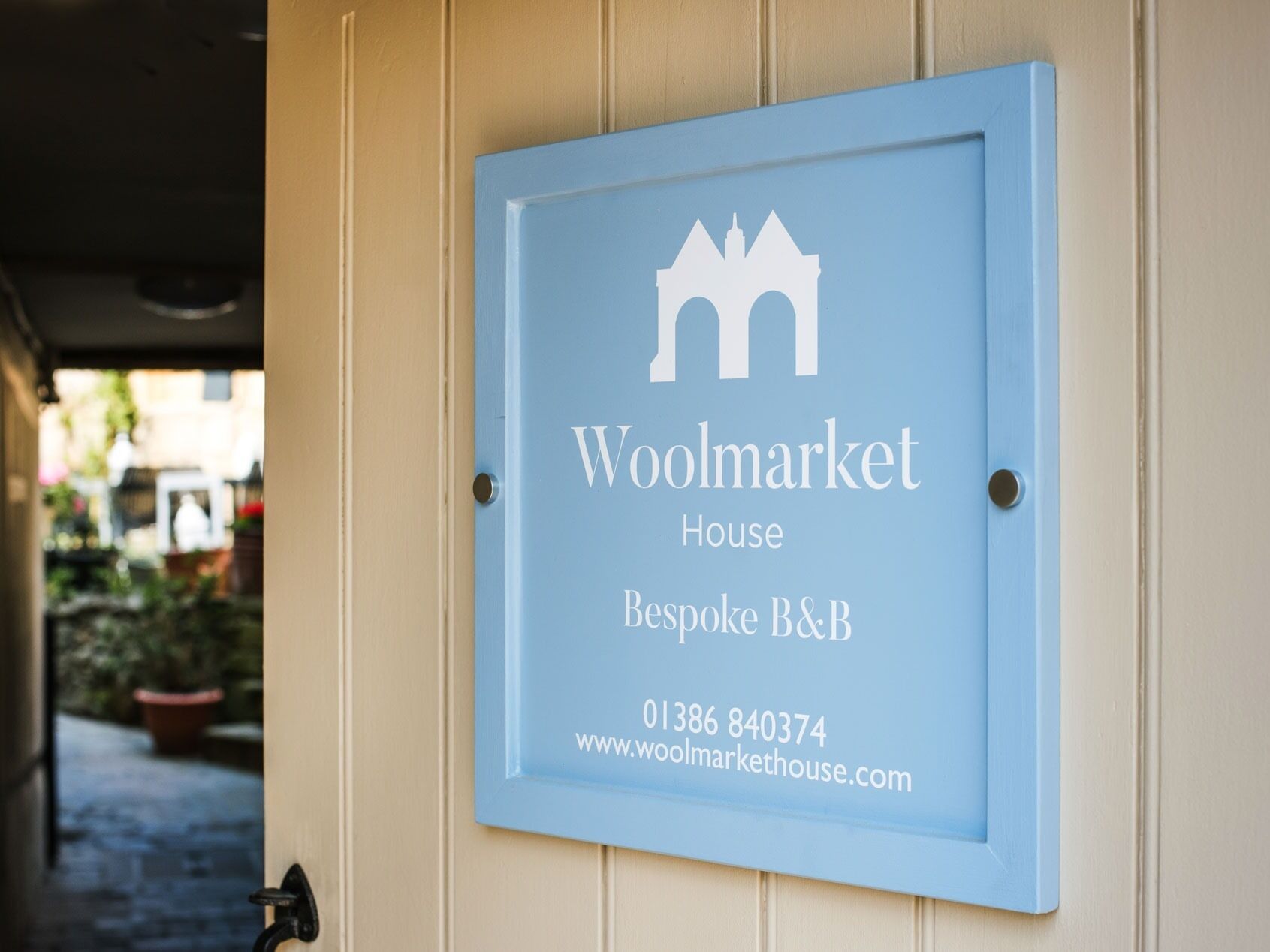 Skilt for Woolmarket House, et individuelt B&B, med kontaktoplysninger og website.
