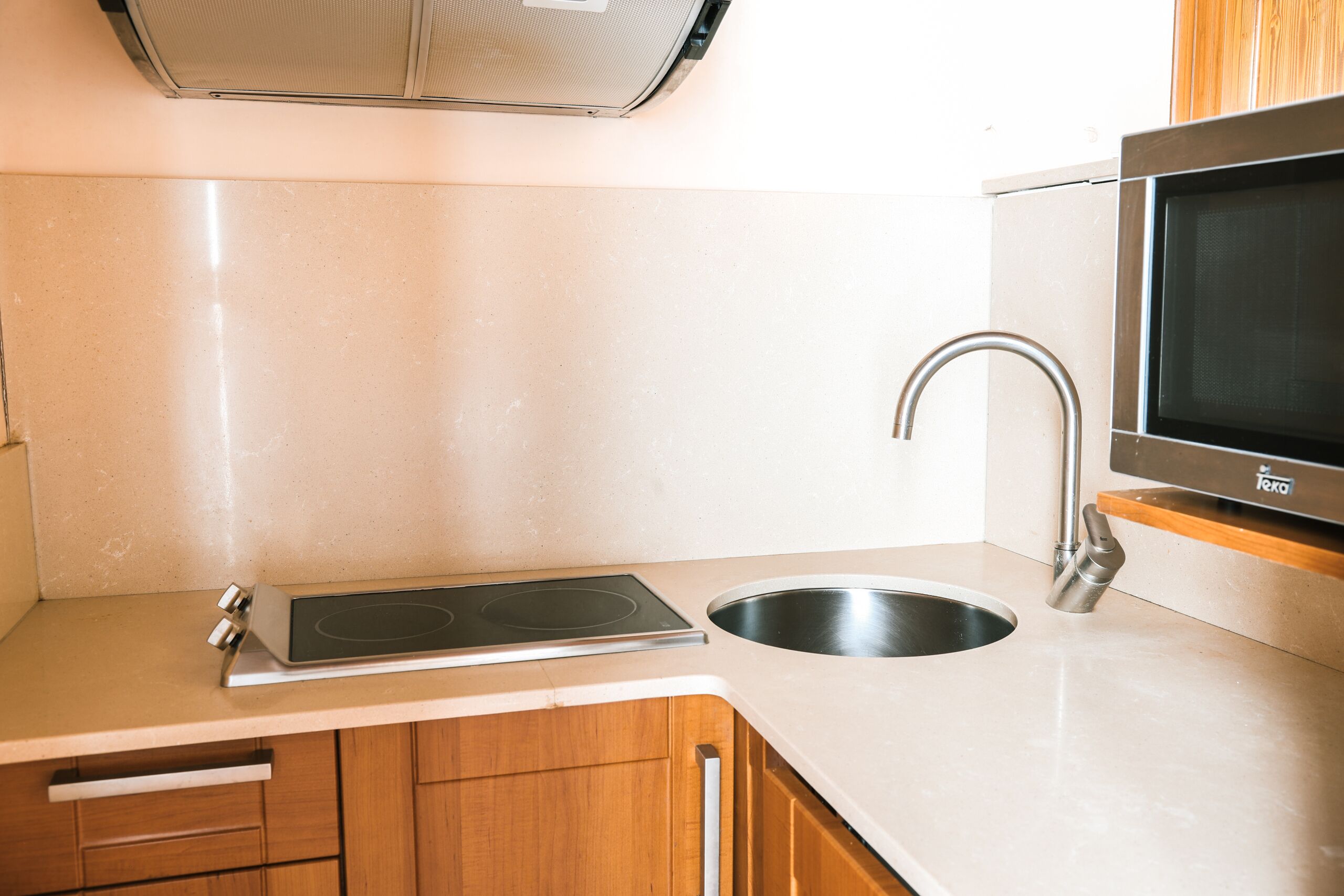 Una cocina con estufa, fregadero y microondas incorporados.